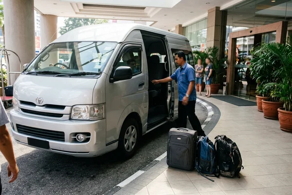 Air-conditioned tour van at a Kuala Lumpur hotel lobby for morning pickup