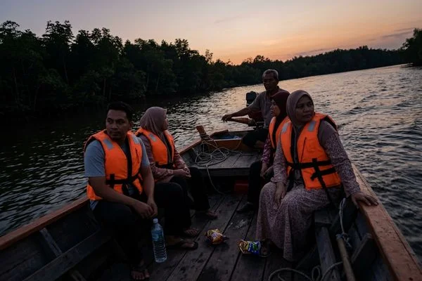 A boat on the Selangor river at dusk watching fireflies in the mangroves