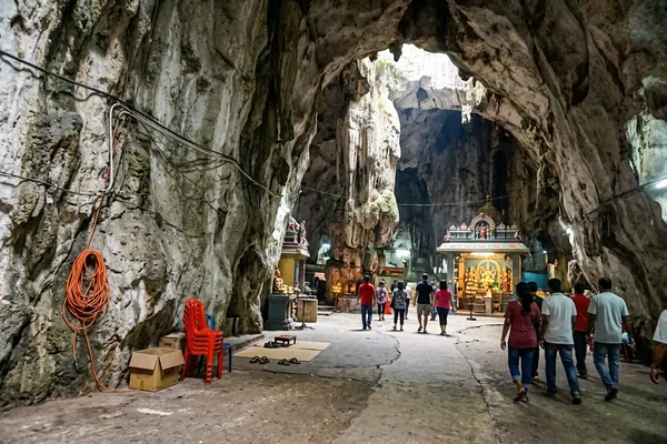 Inside the limestone Temple Cave with shrines and daylight through the roof opening