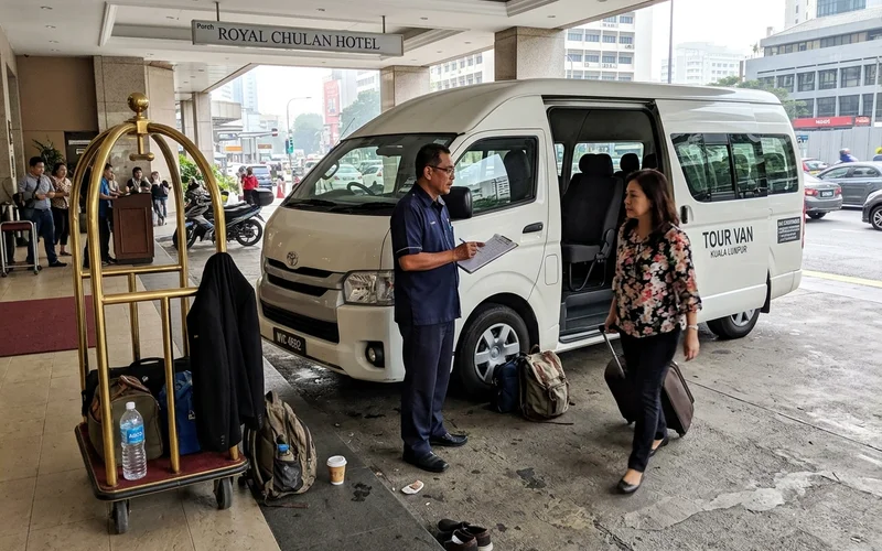 An air-conditioned tour van at a Kuala Lumpur hotel lobby for morning pickup