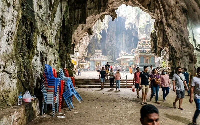 Inside the vast limestone Temple Cave with shrines and shafts of daylight