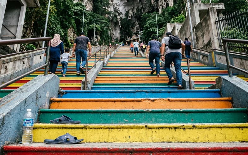 Looking up the steep rainbow staircase at Batu Caves from the base