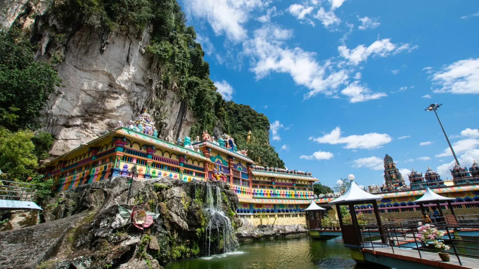 The painted galleries of Cave Villa at Batu Caves above the pond, below the limestone cliff