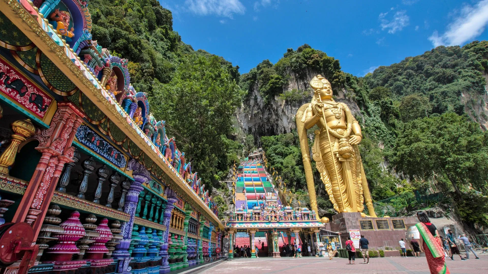 The golden Lord Murugan statue and the rainbow-painted 272 steps rising from the Batu Caves forecourt
