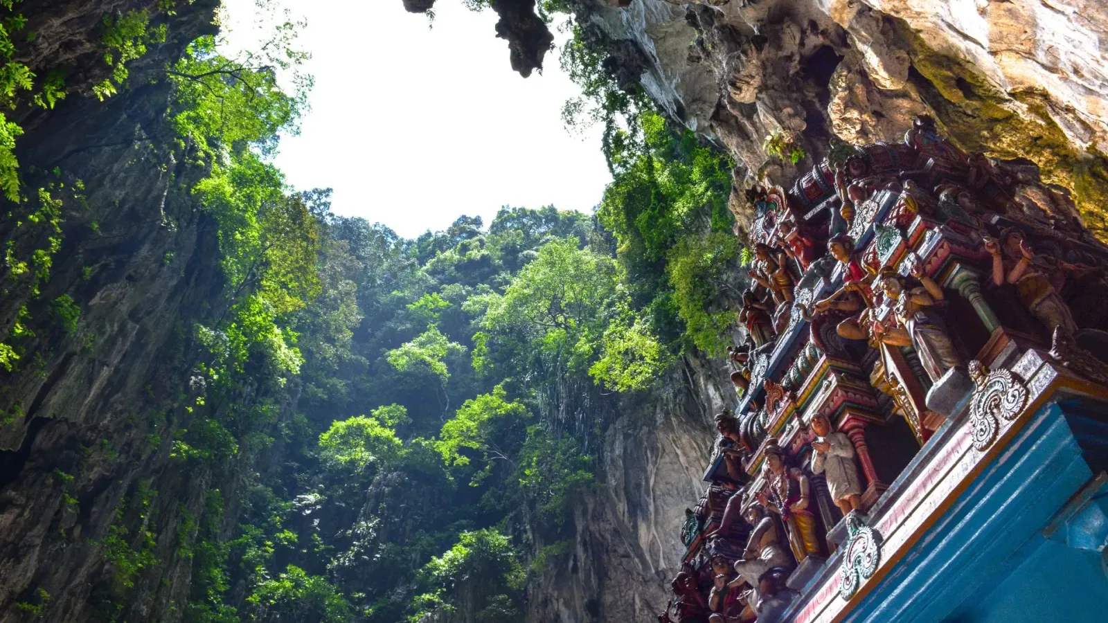 Looking up through the open roof of the Temple Cave at Batu Caves, beside the carved shrine cornice